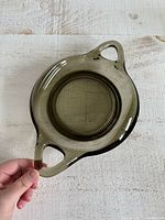 Top view of smoky glass tray showing overall shape, handles, and central ribbed detail