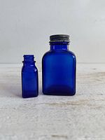 Front view of both cobalt blue bottles showing size difference