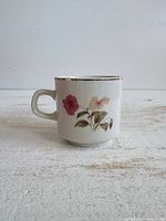 Front view of china mug showing floral pattern and gold rim