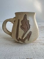 front view of speckled stoneware mug showing leaf motif