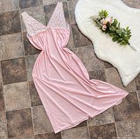 Full front view of pastel pink maxi slip dress laid flat on tile floor