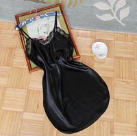 Full view front of black satin slip dress laid flat