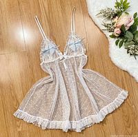 Front view of white polkadot sheer babydoll laid flat