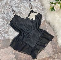 Front view of black satin floral teddy with chiffon ruffle