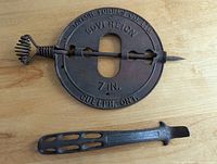 Damper plate with spindle and lid lifter laid on wood surface