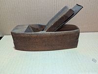 Left side view of full wooden coffin plane with blade and wedge installed