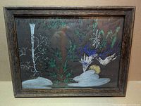 Overall view of framed metallic print behind glass