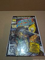 Front view of polybagged comic displaying cover art, issue number, polybag and poster note