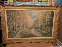 Full view of signed print on canvas in ornate frame