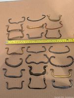 All 21 drawer pulls laid out with tape measure for scale