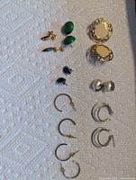 All eight pairs of earrings laid out on white paper towel
