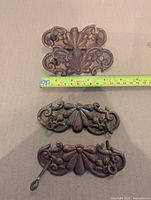 Three backplates with measuring tape showing width around 4.5 in