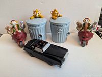 Front view: two Oliver trash-can toys, two Fagin scooter toys, black limousine toy