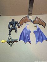 All accessories laid out: stone armor body, brown wing pair, lavender wing pair, crossbow and yellow arrow