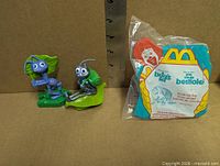 Two loose Flik toys and sealed Dim wind-up toy side by side