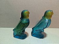 Side view of both glass budgie cologne bottles
