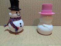 Front view of both Avon snowman milk glass perfume decanters