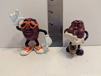 Front view of both PVC California Raisins figures with ruler for scale