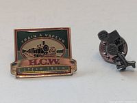 Front view of both lapel pins showing graphics and shape