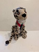 Front view of Heeta the Cheetah plush showing face, collar and Coke bottle accessory