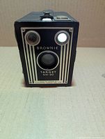 Front view showing Art Deco faceplate, lens, viewfinders and model branding