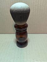 Full view of amber glass bottle with brush cap