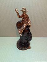 Front view of brown glass bucking bronco bottle with cowboy cap