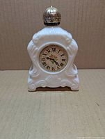 Front view showing clock face, milk glass shape, gold cap