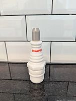 Front view of milk glass Champion spark plug bottle
