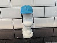 Front view of Snoopy milk glass decanter with blue cap