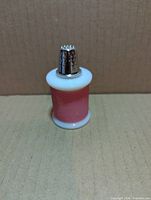 Front view of Avon milk glass spool perfume bottle with thimble cap