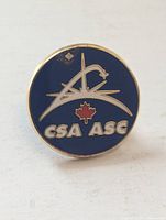 Front view of round blue enamel CSA-ASC lapel pin