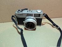 Front view of Canon Canonet 28 camera showing lens and strap