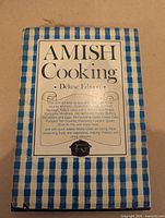 Front cover of Amish Cooking Deluxe Edition cookbook showing title and design