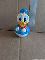 Front view of Donald Duck roly poly toy with ruler for scale