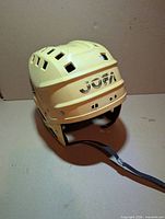Front angled view of yellow JOFA hockey helmet showing logo and chin strap