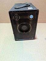 Front view showing lens, viewfinder windows, textured covering