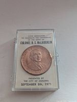 Front view of medallion in original display case showing portrait and event details