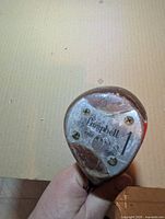 Close-up of the Campbell persimmon club head showing branding and condition