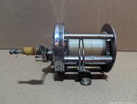 Right side view showing frame, spool with line, chipped yellow cap