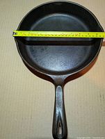 Top view showing interior cooking surface and measuring tape indicating 11 inch diameter