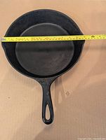Top view of skillet with tape measure across showing 11-inch diameter, interior surface visible