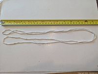 Full view of necklace alongside measuring tape showing 52-inch length