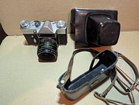 Camera, lens and disassembled leather case shown