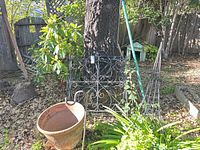 Group shot: terracotta planter, wrought iron panel, two obelisk trellises, shepherd’s hook