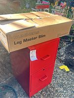 Red filing cabinet with boxed Summers Leg Master Slim on top