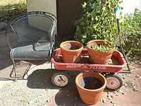 Overview of patio chair, Radio Flyer wagon and four terracotta pots