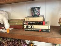 Shelf view with books, goose figurine, ceramic cup