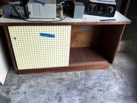 Full front view of credenza showing pegboard door and open compartment