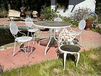 full view of patio table with four chairs by poolside